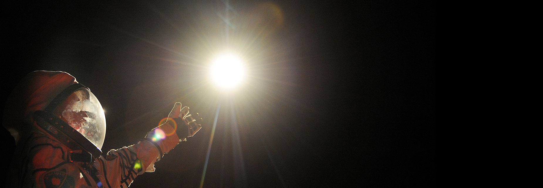 An astronaut reaches towards a star