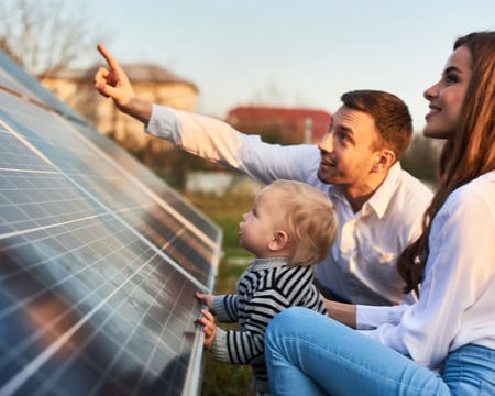 Grid image showing family beside solar panel