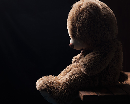 A lost teddy bear waits patiently for its owner to return