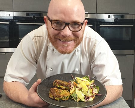 Gary Maclean smiles as he shows off a plate of spiced quinoa cakes