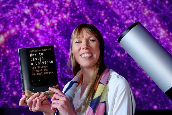Prof. Catherine Heymans holding her book, How to Design a Universe