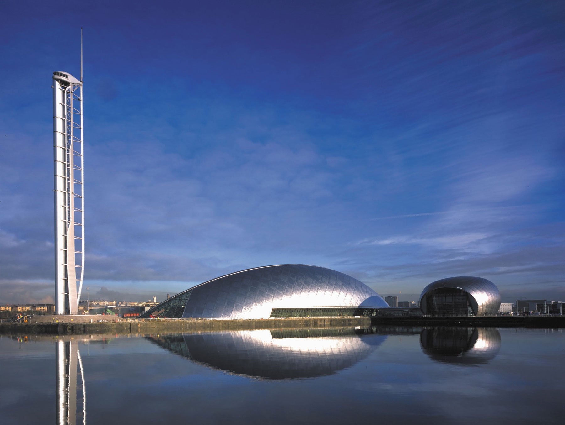 Glasgow Tower and science centre buildings and their reflection in water.