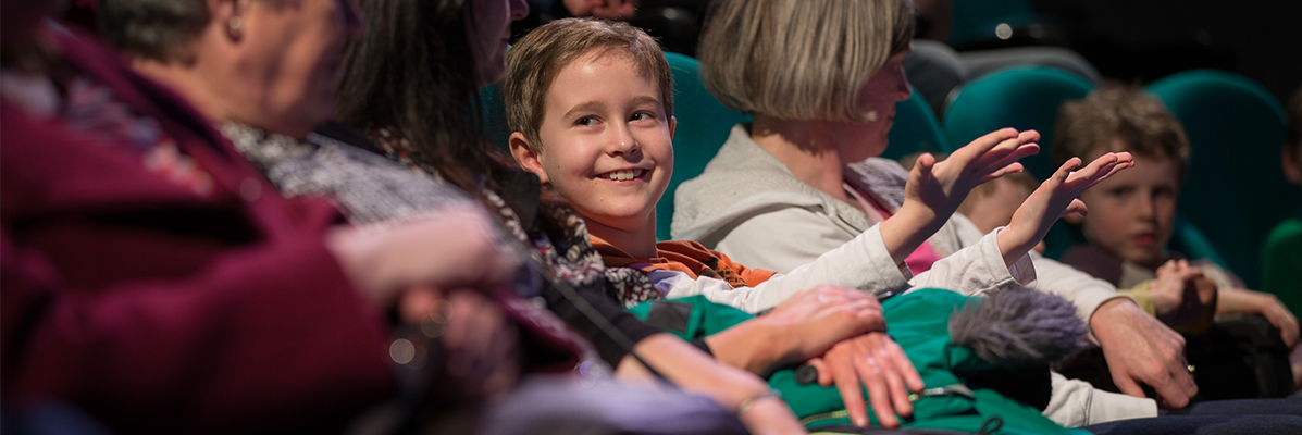 Child sitting with adults in Science Show Theatre