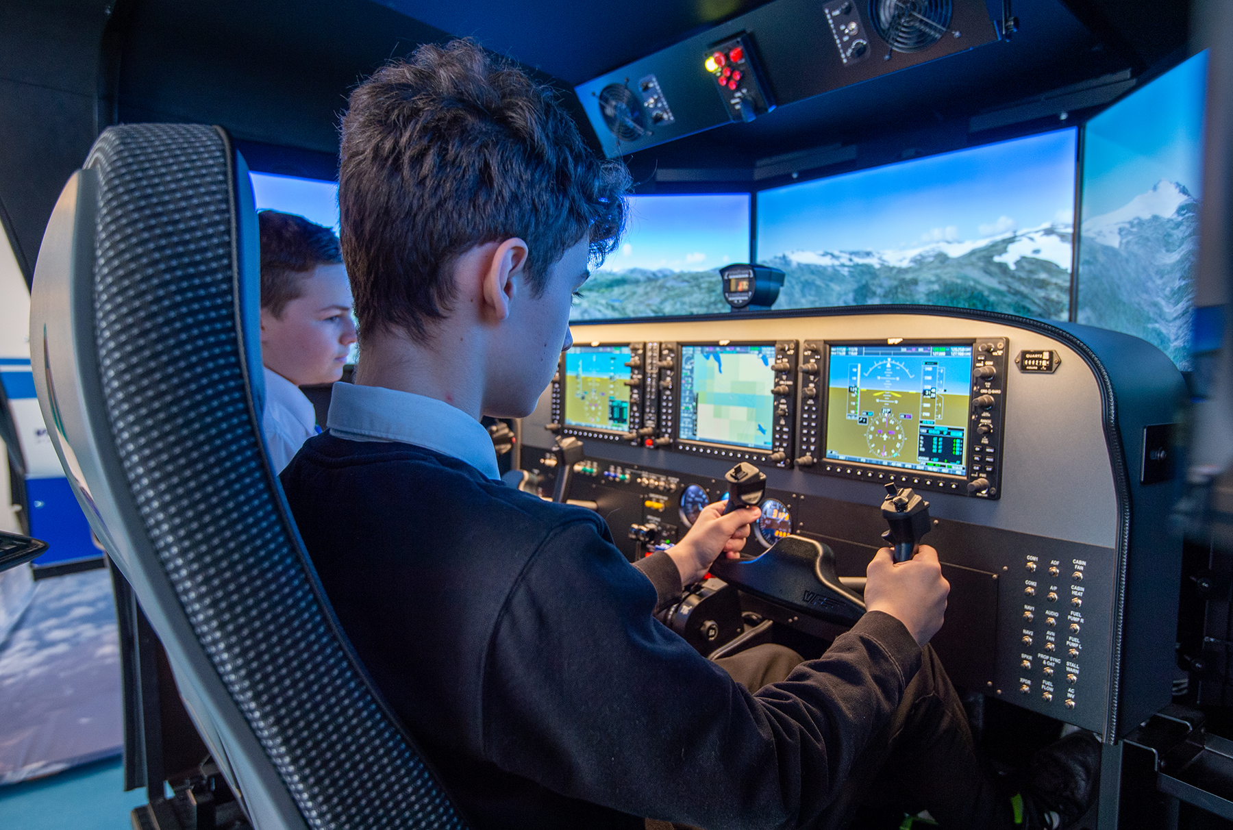 Two school pupils at the controls of a flight simulator