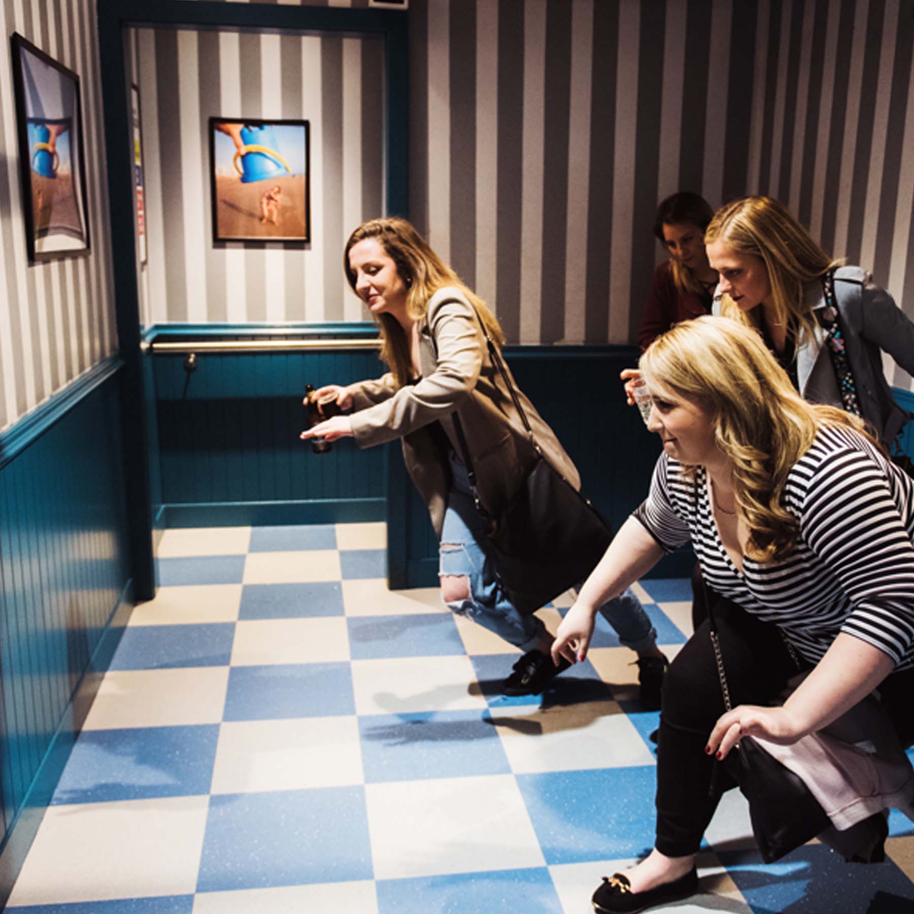 A group of people lean forwards as they try to walk through the Wacky Salon