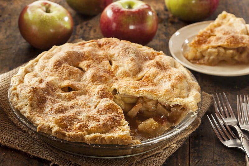 An apple crumble pie with a slice removed