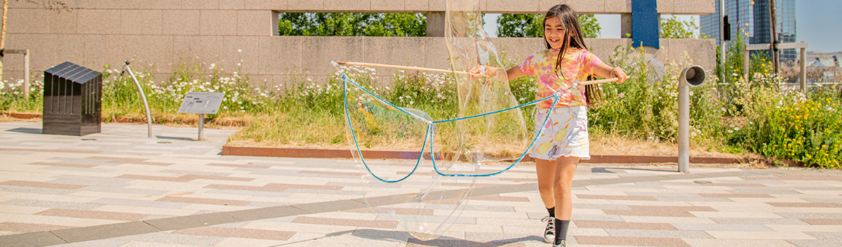 A young girl makes giant bubbles in the Fibonacci Garden. Photo: Paul Watt