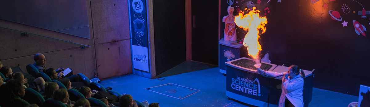 science communicator makes a sugar fireball during a science show