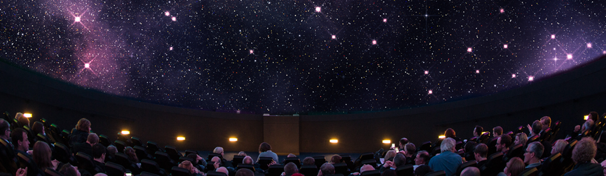 an audience watches a planetarium show