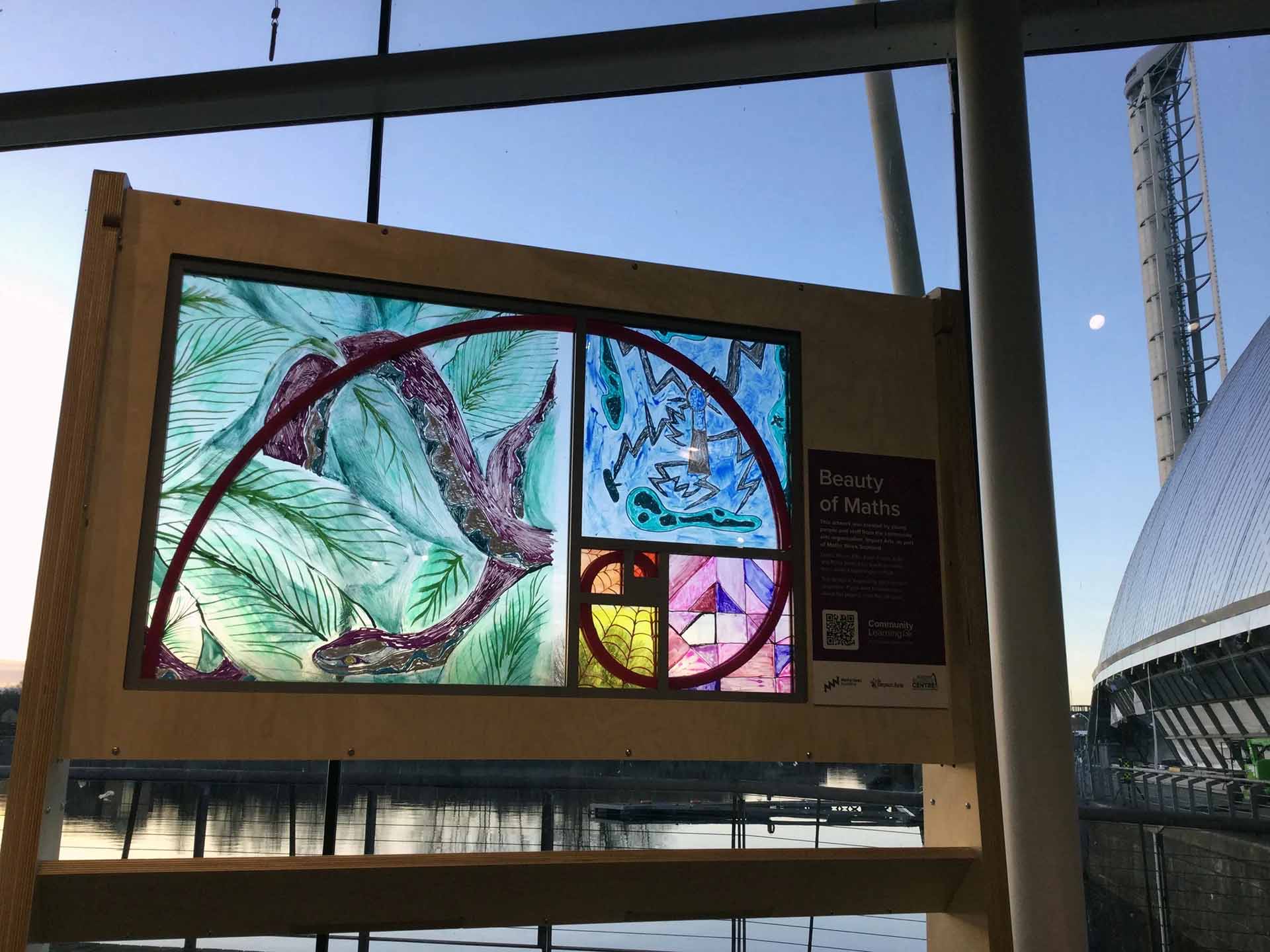 A Fibonacci spiral within a colourful stained glass exhibit at Glasgow Science Centre
