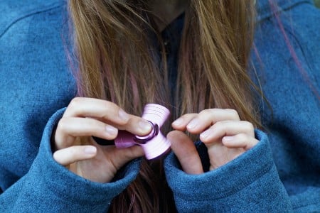 Someone holding a spinning fidget spinner