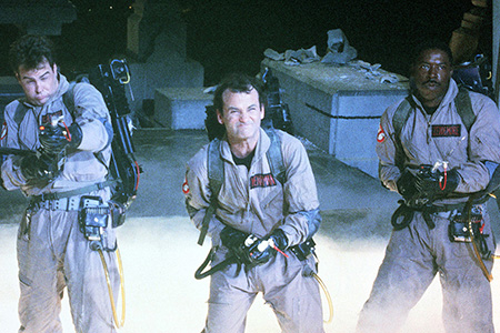 Four ghostbusters with their ghost capturing equipment.