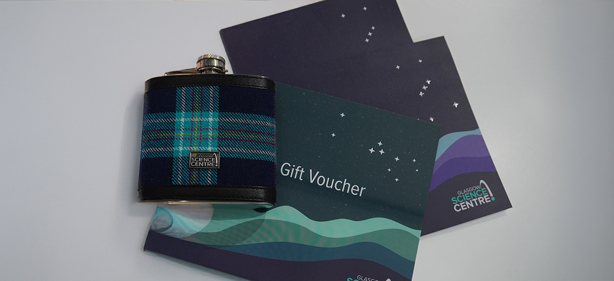 a glasgow science centre tartan flask alongside some gift vouchers