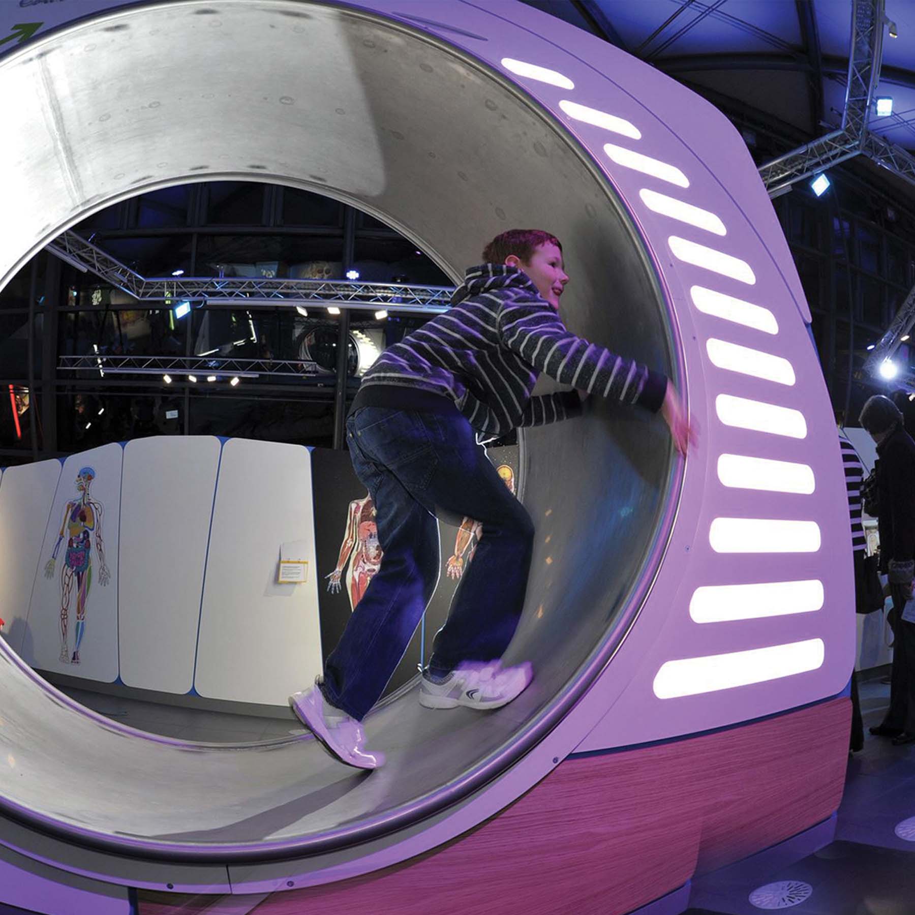 A person runs in a giant hamster wheel