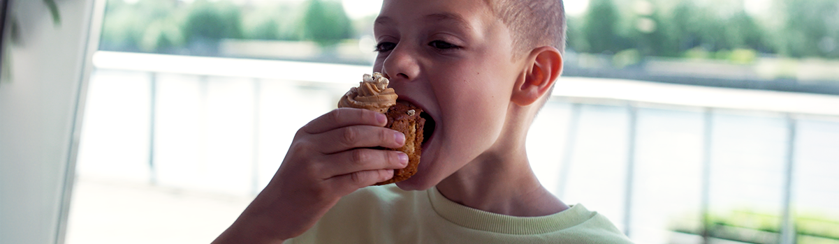 Child enjoying a tasty cake from the cafe