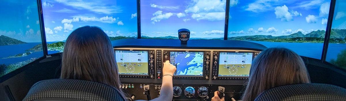 two children at the control of the flight simulator
