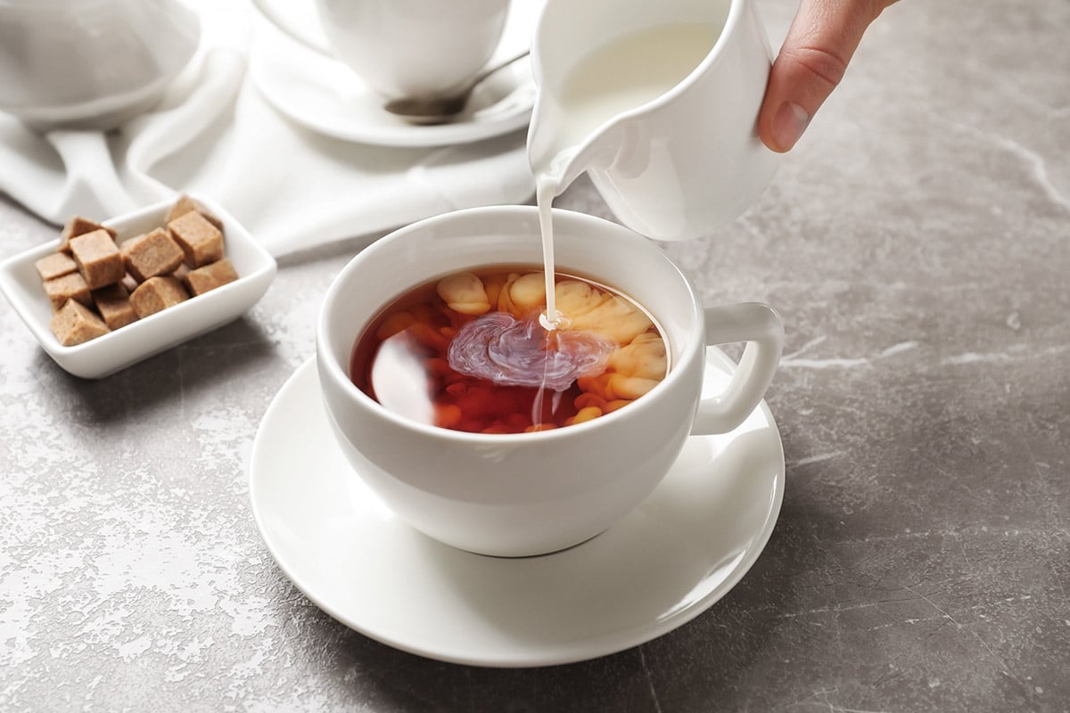 Pouring milk into a cup of tea