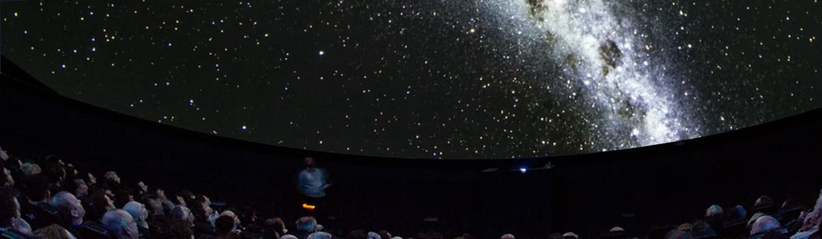 A Planetarium audience gaze up at the Milky Way and stars