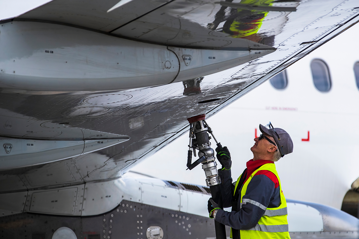 Ground crew refill an aircraft with aviation fuel