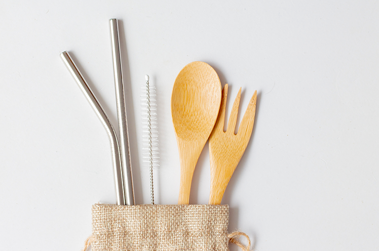 Image of stainless-steel straw, cleaner and a wooden fork and spoon