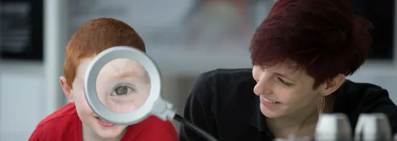 Teacher/expert shows pupil a magnifying glass