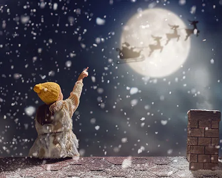 child pointing at moon as santa flies past