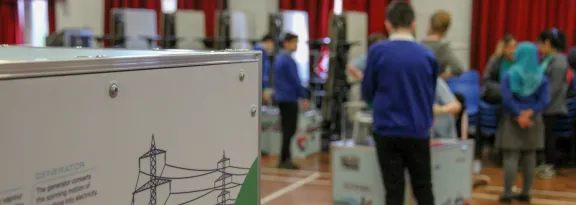 Powering The Future exhibits setup and being explored by pupils in a school hall. Slightly pulled focus to emphasis detail on side of exhibit casing.