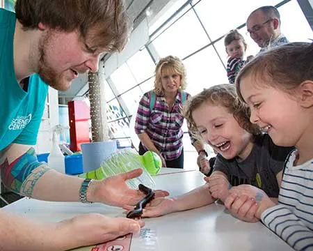 Children watching a demonstration by a science communicator