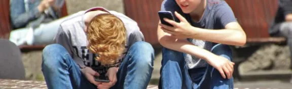 Two boys looking at phones