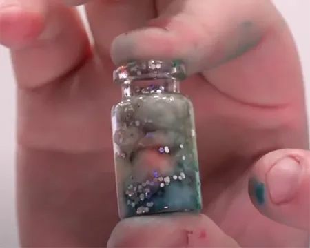 A close up of a nebula in a jar - a glass vial with cotton wool and colouring