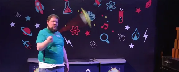 Presenter CJ spins a spinning tray in the science show theatre