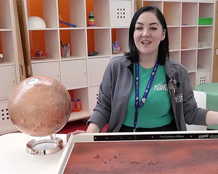 Presenter, Veronica, with a globe of Mars and a model of its surface
