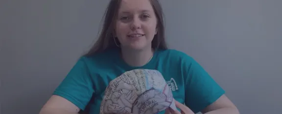 Presenter Caitlin holds a brain hat