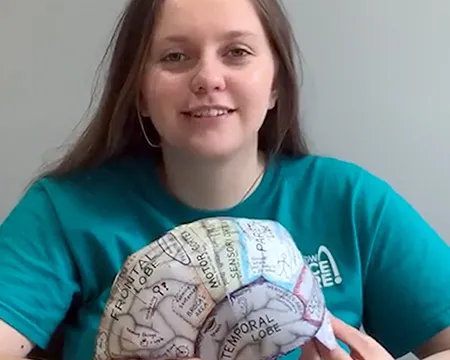 Presenter Caitlin holds a brain hat