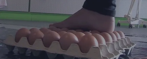A foot on top of a tray of eggs