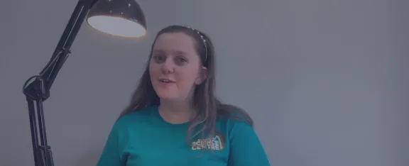 Presenter Caitlin sits beside an illuminated lamp