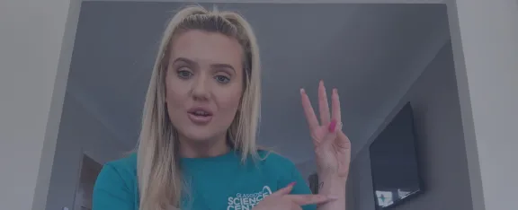 Presenter Celine with holds her hand up with three fingers extended