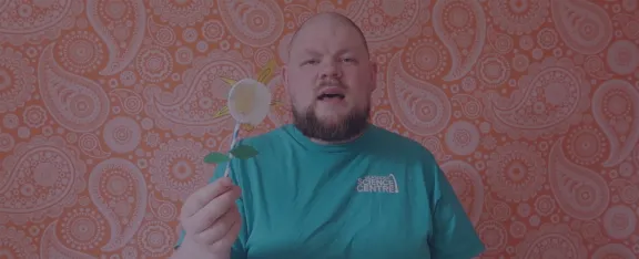 Presenter CJ holds up a paper flower