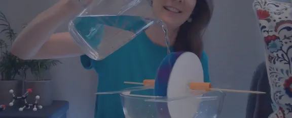 Pouring water on a homemade water wheel