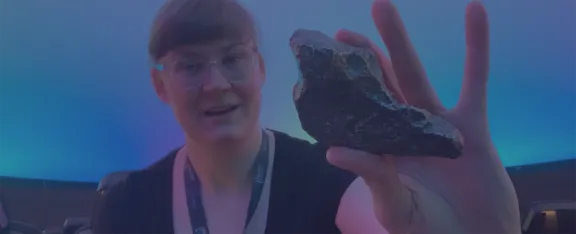 Presenter Nina holds a meteorite in her hand