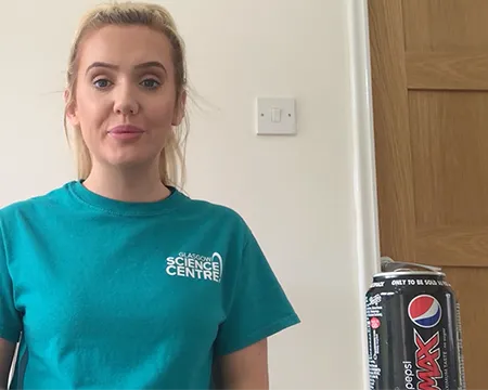 Presenter Celine sits at a table beside an empty drinks can