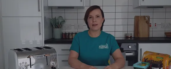 Alicia sits in the kitchen beside a toaster