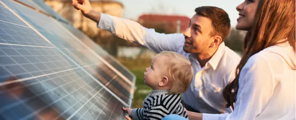 Banner image showing family beside solar panel