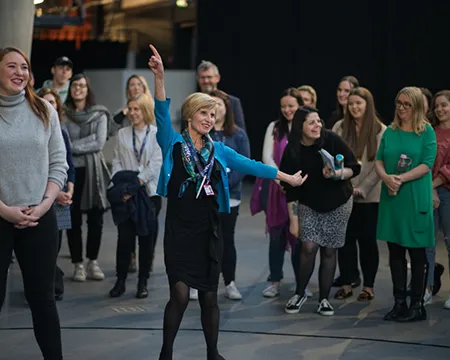 A staff member has their arms outstretched.