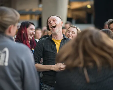 A GSC member of staff smiles surrounded by colleagues