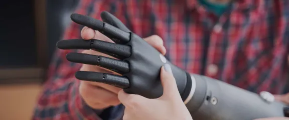 An engineer shows an artificial limb to another person