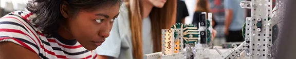 Two Female College Students Building Machine In Science Robotics Or Engineering Class