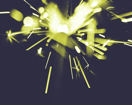 A yellow and white spark radiates from the top of a dark blue background.