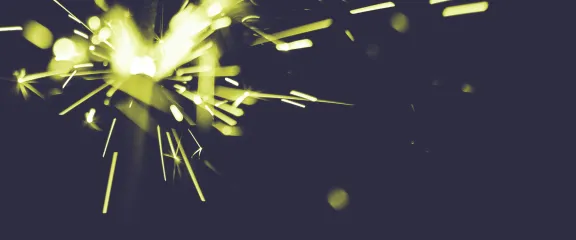 A yellow and white spark radiates from the top left of a dark blue background.