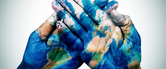 hands painted to represent the Earth are overlapped